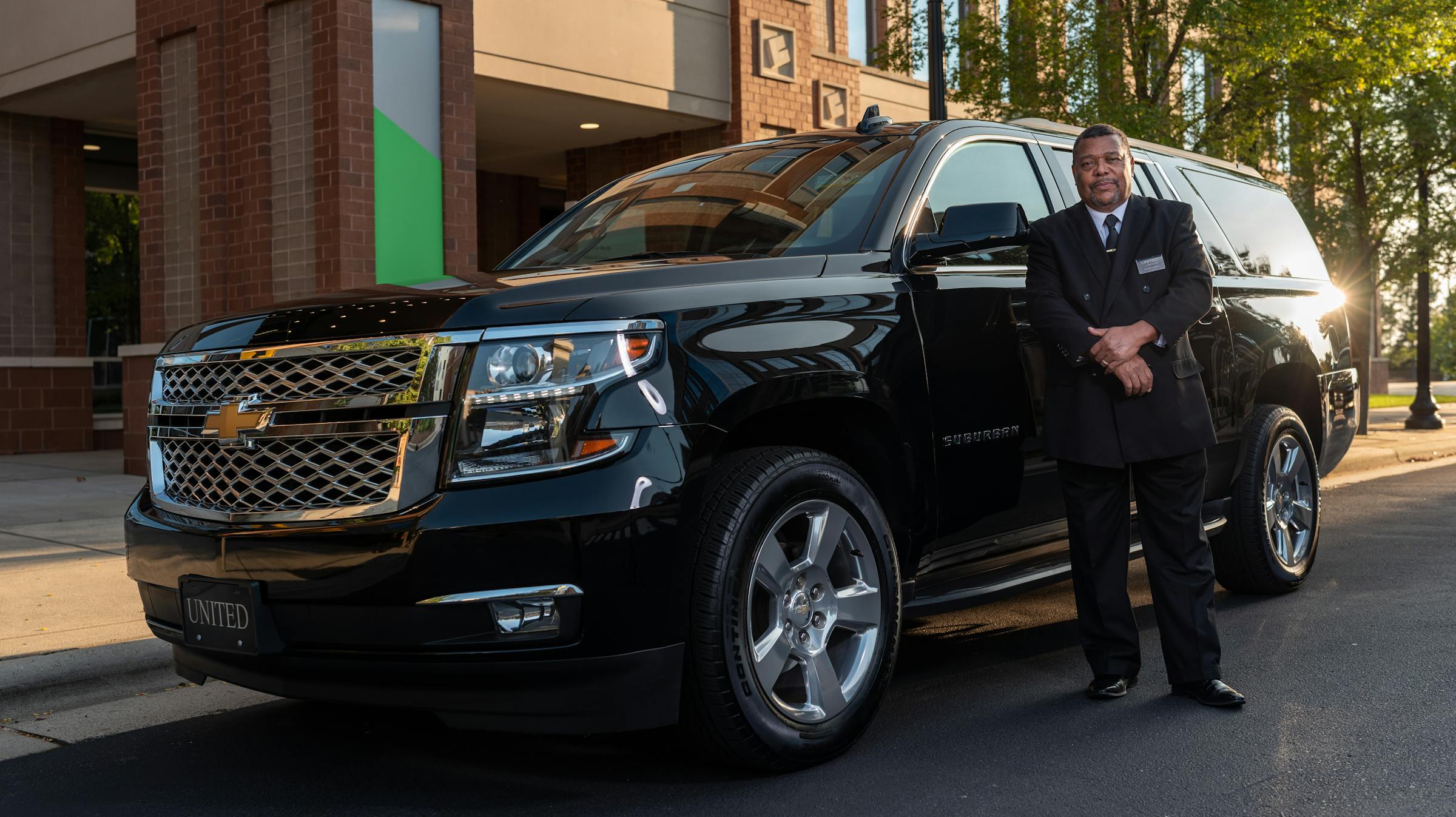 Chofer ejecutivo profesional junto a SUV negro